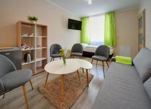a living room with a couch and a table and chairs at Pensjonat Olympia w Przesiece in Przesieka