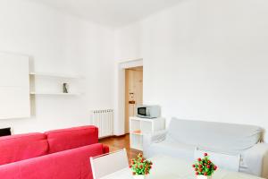 een woonkamer met een rode bank en een tafel bij Migliarina Cozy Apartment in La Spezia