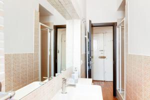 Baño con 3 lavabos y espejo en Migliarina Cozy Apartment, en La Spezia