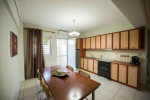 a kitchen with a wooden table and a dining room at Marias BBQ Garden House in Kalamata +9 photos
