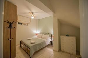 a bedroom with a bed and a dresser at Marias BBQ Garden House in Kalamata