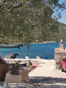 a view of a body of water with a group of chairs at Apartmani Bezek in Ston