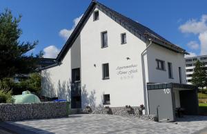 a white building with a sign on the side of it at Appartementhaus kleines Glück &MeineCardPLUS in Willingen