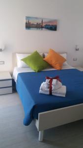 a bed with colorful pillows on it in a room at B&B TRA CIELO e MARE in Pietra Ligure