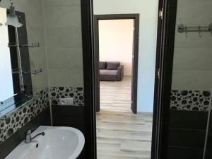 La salle de bains est pourvue d'un lavabo, d'un miroir et d'un canapé. dans l'établissement David Palace Hotel Ureki, à Ureki