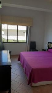 sypialnia z fioletowym łóżkiem i oknem w obiekcie Skol 134C by Completely Marbella w Marbelli