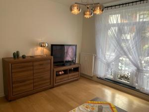 een woonkamer met een flatscreen-tv op een dressoir bij Appartement Chez Agnes in Brussel