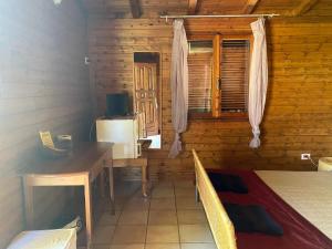 a bedroom with a desk and a bed in a wooden cabin at I Giardini Di Margius in Itri