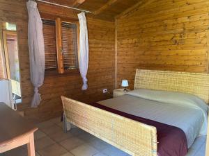a bedroom with a bed in a log cabin at I Giardini Di Margius in Itri