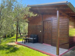 a wooden cabin with a bench and a table at I Giardini Di Margius in Itri