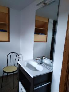 La salle de bains est pourvue d'un lavabo, d'un miroir et d'une chaise. dans l'établissement Le Breuil, à Piney