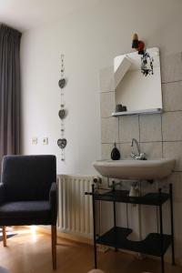 a bathroom with a sink and a chair at Hofstede Villetta in Zonnemaire