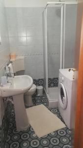 een badkamer met een wastafel, een toilet en een douche bij Studio apartman Erika in Ližnjan