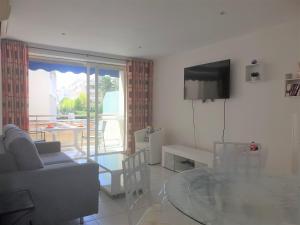 uma sala de estar com uma mesa de vidro e uma televisão em LES ALGUES T2 em Cannes