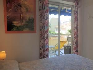 a bedroom with a bed and a window with a view at LES ALGUES T2 in Cannes