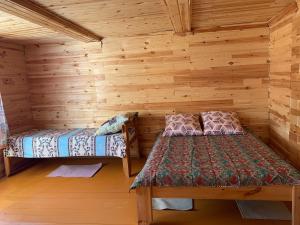 フジュルにあるRybatskiy Beregのログキャビン内のベッド2台が備わる部屋です。