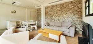a living room with a couch and a table at BnBIsrael apartments - Dizengoff Brique in Tel Aviv