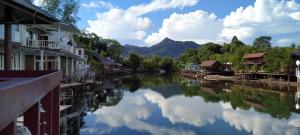 a river in a town with houses and mountains at Sapparot Bar & Bungalows in Ko Chang