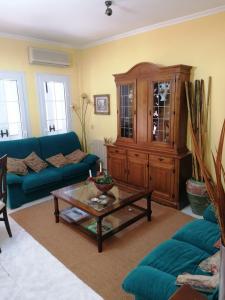 Atico في Calamonte: غرفة معيشة مع أريكة زرقاء وطاولة قهوة