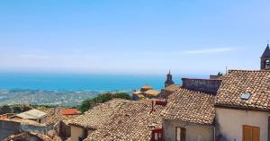 - une vue sur les toits d'une ville avec des montagnes en arrière-plan dans l'établissement Perla Del Borgo Appartamenti, à Santa Caterina dello Ionio