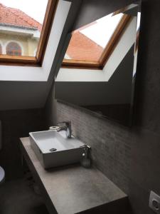 a bathroom with a sink and a mirror at Cyrano Vendégház in Vonyarcvashegy