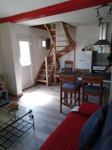 sala de estar con mesa y sillas y escalera en Le Breuil, en Piney