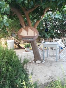 a tree with a table and a bowl on a tree at Kelly's in Chrissi Akti