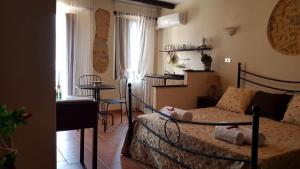 1 dormitorio con cama, mesa y cocina en Perla Del Borgo Appartamenti, en Santa Caterina dello Ionio