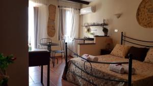 ein Schlafzimmer mit Bett und Tisch und eine Küche in der Unterkunft Perla Del Borgo Appartamenti in Santa Caterina dello Ionio