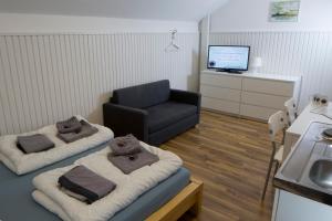 een woonkamer met een bank en een stoel bij Flensbed Hotel & Hostel in Flensburg