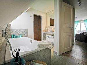 ein Bad mit einer Badewanne in einem Zimmer in der Unterkunft Apartmenthaus Gurtdeel 4 in Hörnum