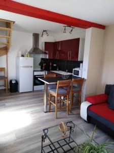 cocina y sala de estar con mesa y sofá en Le Breuil, en Piney