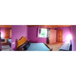 um quarto com paredes roxas, uma cama e um sofá em CASA "O Campo" em Sober