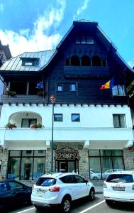 two cars parked in front of a building at Excelsior Boutique Hotel Sinaia in Sinaia