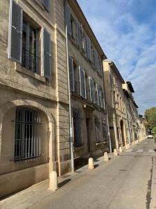 an empty street next to a building with windows at Apartment Limas in Avignon
