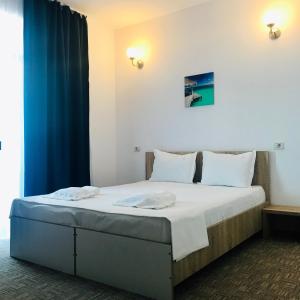 - une chambre avec un grand lit et un rideau bleu dans l'établissement RIMA Del Mar, à Eforie Nord