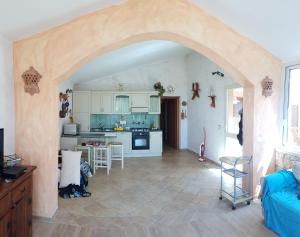 una cocina con un arco que conduce a una sala de estar en Sardinia Sea Vacation Villa, en Costa Paradiso