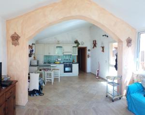 a kitchen with an archway leading into a living room at Sardinia Sea Vacation Villa in Costa Paradiso