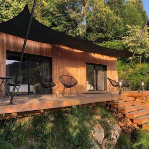 een houten terras met een tent en stoelen erop bij Casa Santa Lucia in Bocognano