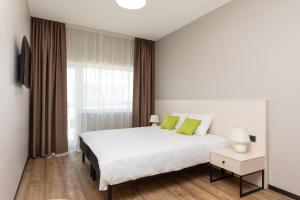 a bedroom with a white bed and a large window at U11 Hotel & SPA in Tallinn