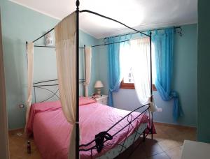 1 dormitorio con 1 cama con sábanas rosas y paredes azules en Sardinia Sea Vacation Villa, en Costa Paradiso
