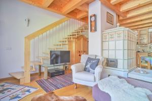 a living room with a couch and a tv and stairs at Supperior Appartement in Rasùn di Sotto