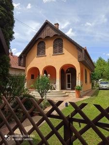 a house with a wooden fence in front of it at Almavilla in Gyenesdiás