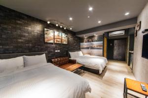 羅東鎮的住宿－羅東夜市坦智能旅店 ，一间卧室设有两张床和砖墙