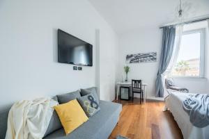 uma sala de estar com um sofá e uma televisão na parede em Suite 36 - NEW OPENING em Roma