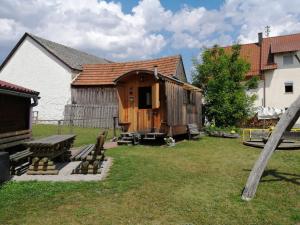 una cabaña de madera en el patio de una casa en Schäferwagen auf dem Ferienhof Stark en Kelheimwinzer