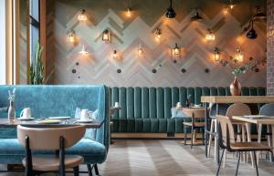a restaurant with a blue couch and tables at Hotel Indigo Dresden - Wettiner Platz by IHG in Dresden