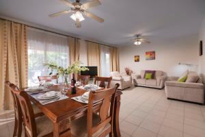 a living room with a wooden table and chairs at Resitour - Limnaria Gardens in Paphos City