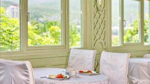 una mesa con dos platos de comida y dos ventanas en Villa Bonne Maison, en Alushta