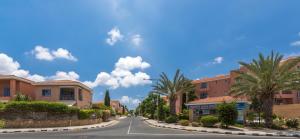 an empty street in a residential neighborhood with palm trees at Resitour - Limnaria Gardens in Paphos City